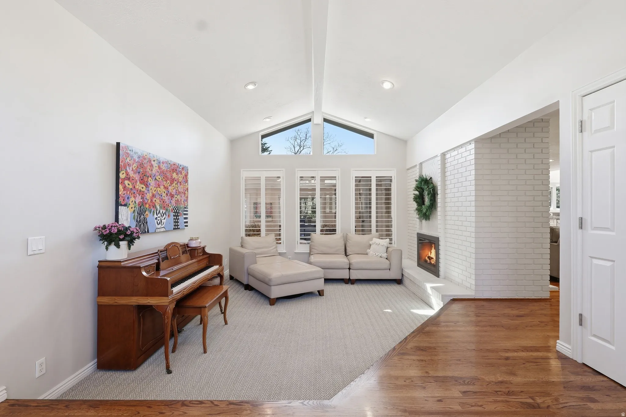 Living area featuring wood finished floors, a brick fireplace, and recessed lighting