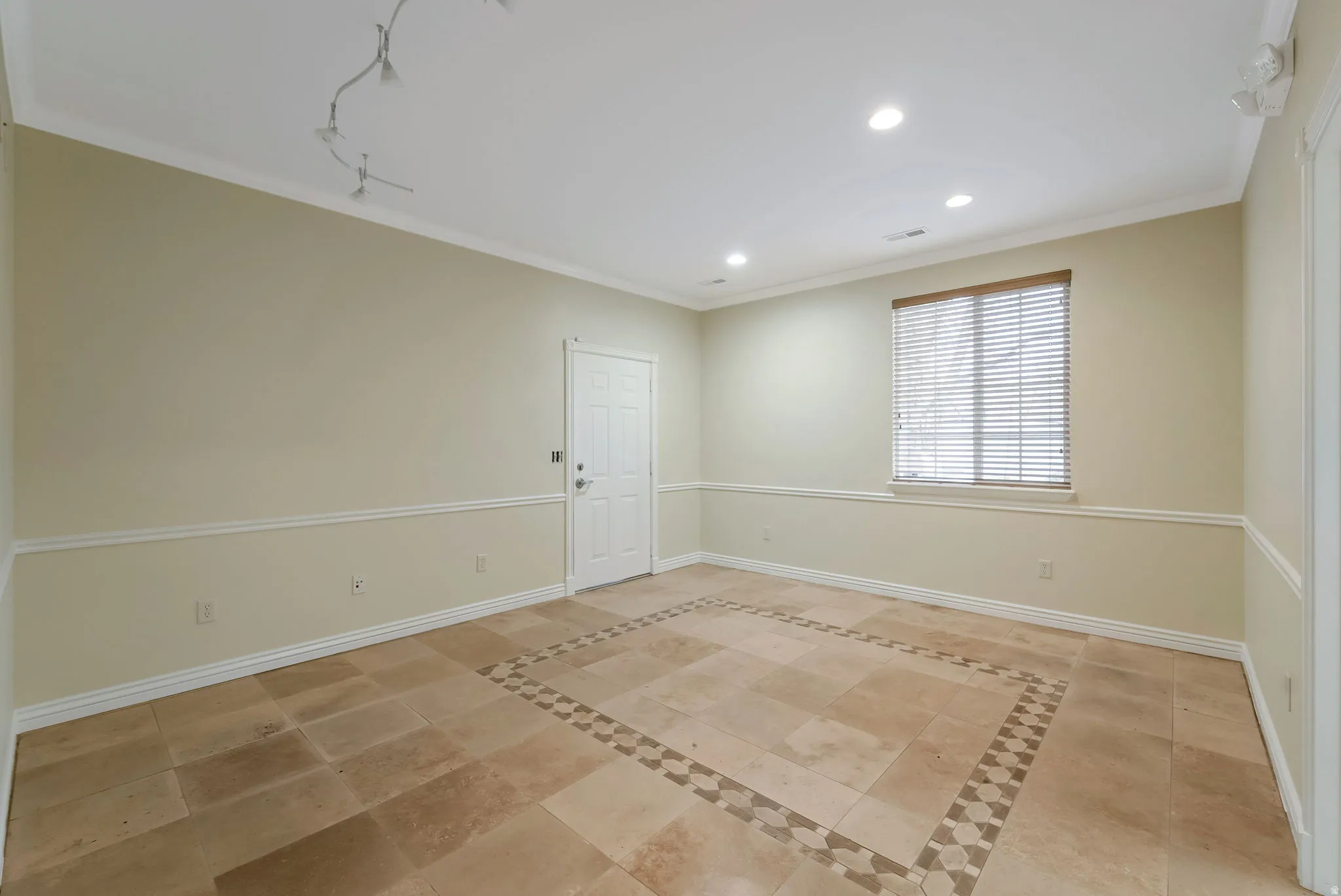 Empty room with ornamental molding and recessed lighting