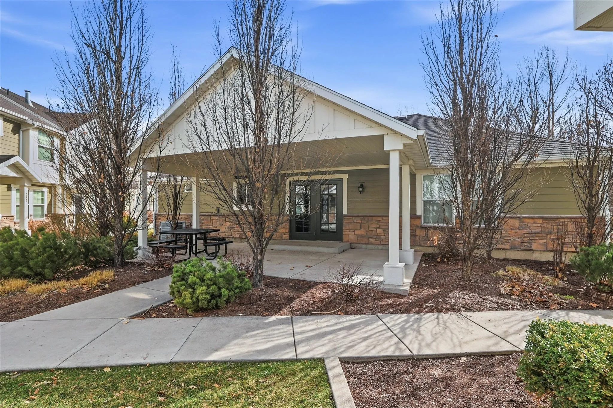 View of front of house featuring a porch, stone siding, and a shingled roof