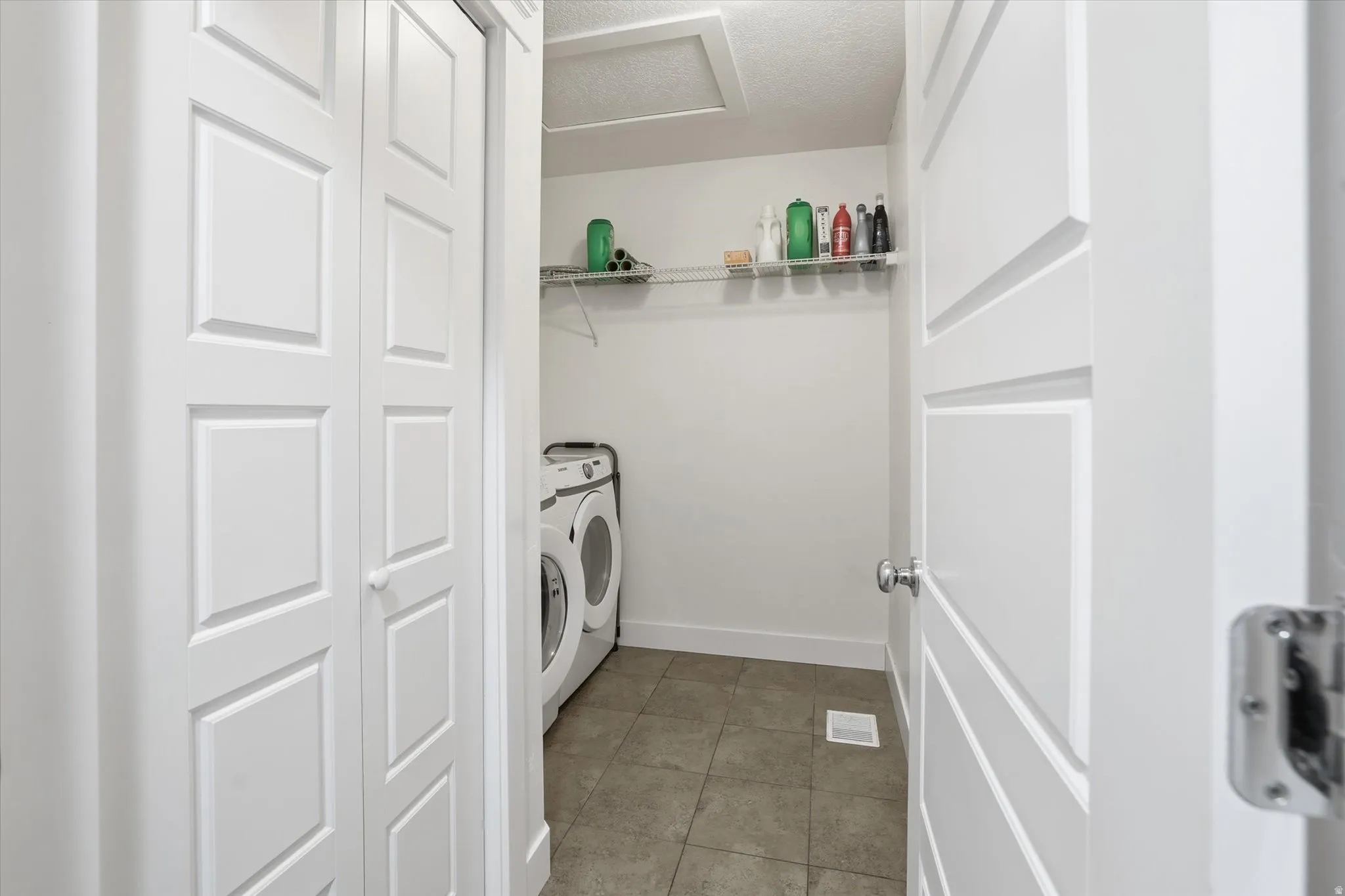 Laundry area featuring washer and dryer and light tile patterned flooring