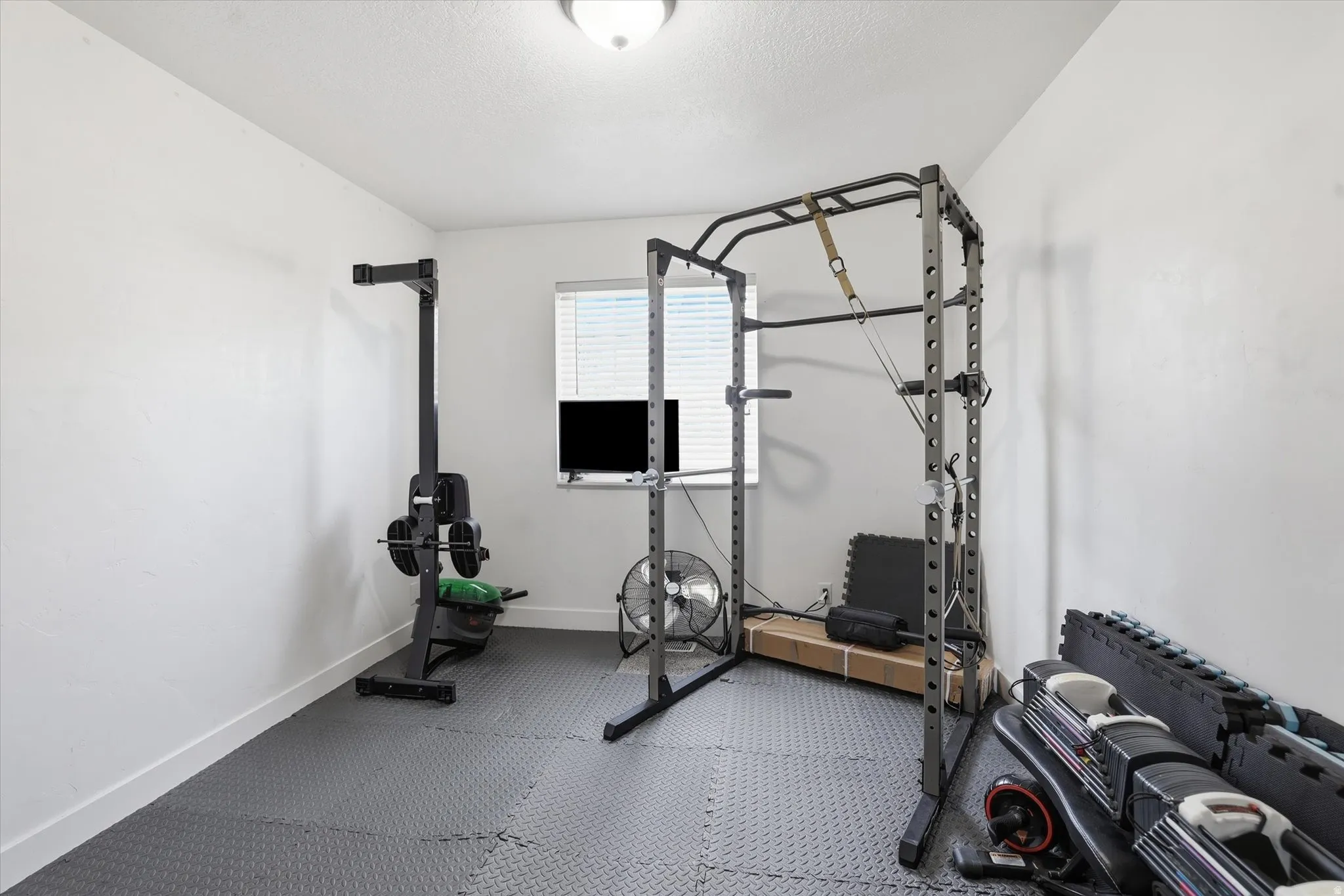 Exercise room featuring rubber floors and baseboards