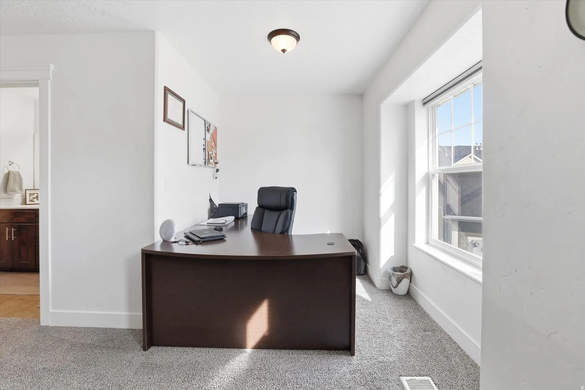 Office area featuring light carpet and baseboards
