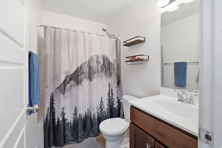 Bathroom featuring vanity, a shower with curtain, and a textured ceiling