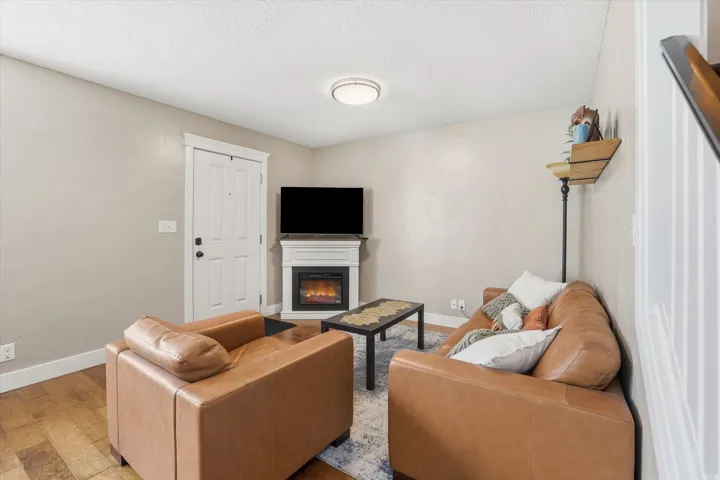 Living area featuring a glass covered fireplace and wood finished floors