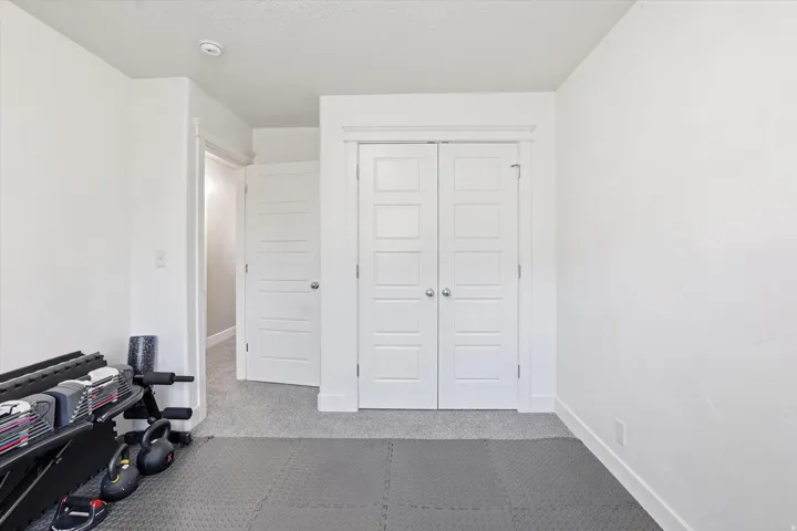 Exercise area with light colored carpet and baseboards