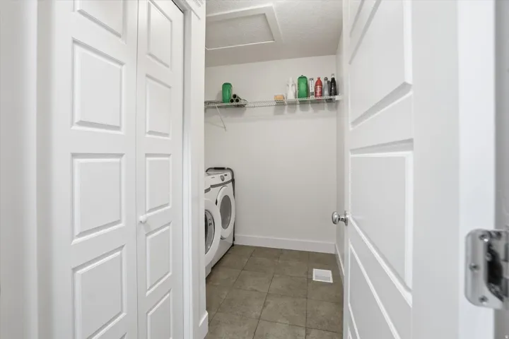 Laundry area featuring washer and dryer and light tile patterned flooring