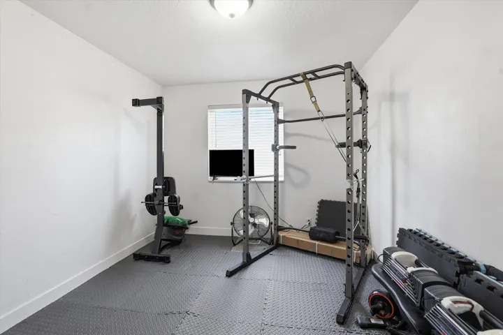 Exercise room featuring rubber floors and baseboards