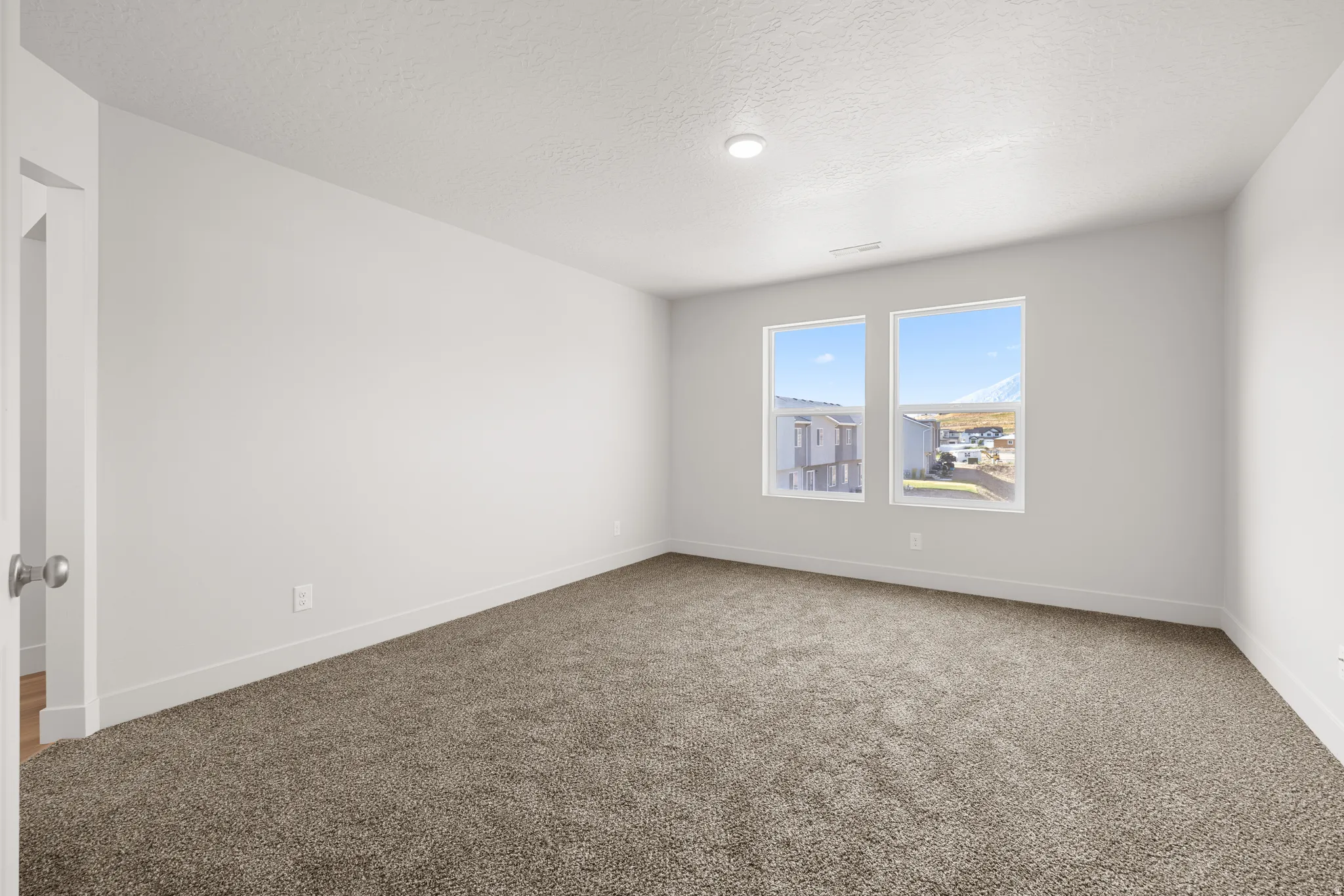 Unfurnished room featuring carpet floors and a textured ceiling