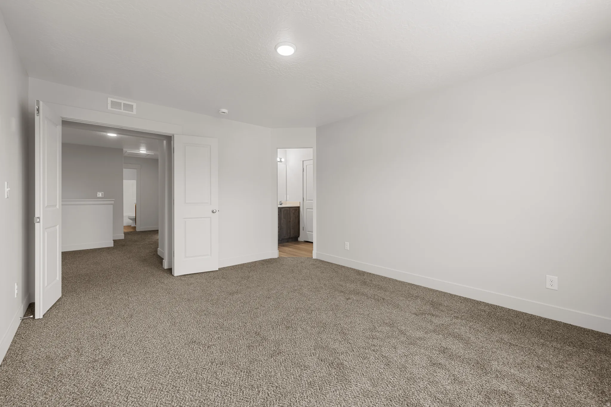 Unfurnished bedroom with carpet and connected bathroom