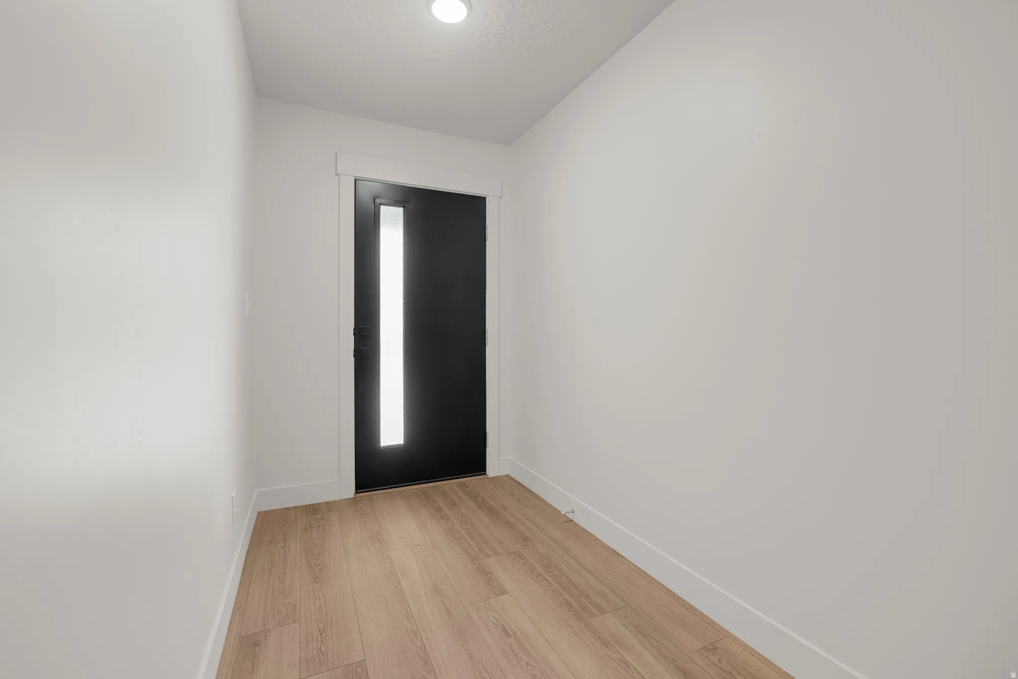 Foyer featuring baseboards and light wood finished floors