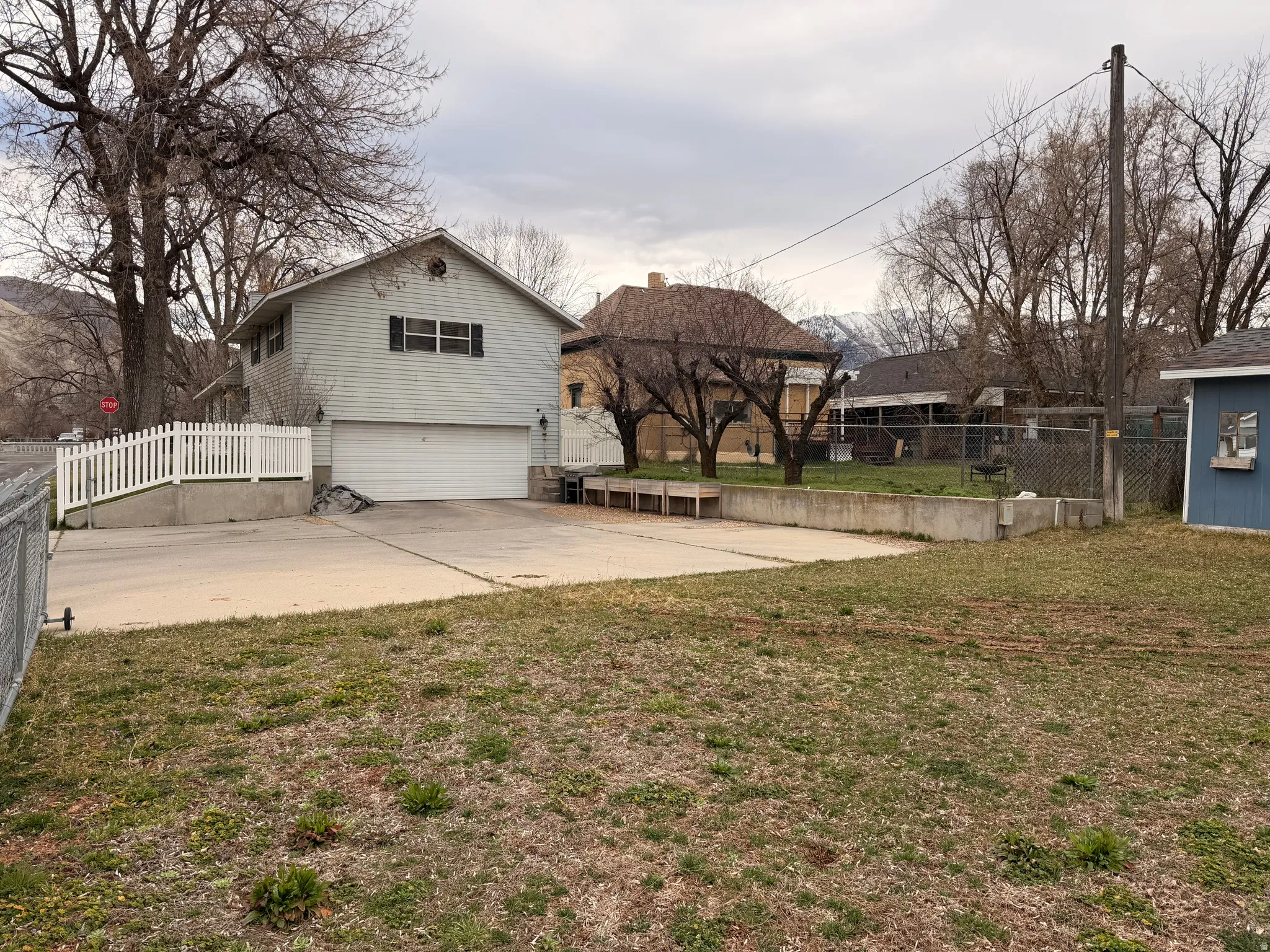 View of yard featuring an attached garage and concrete driveway