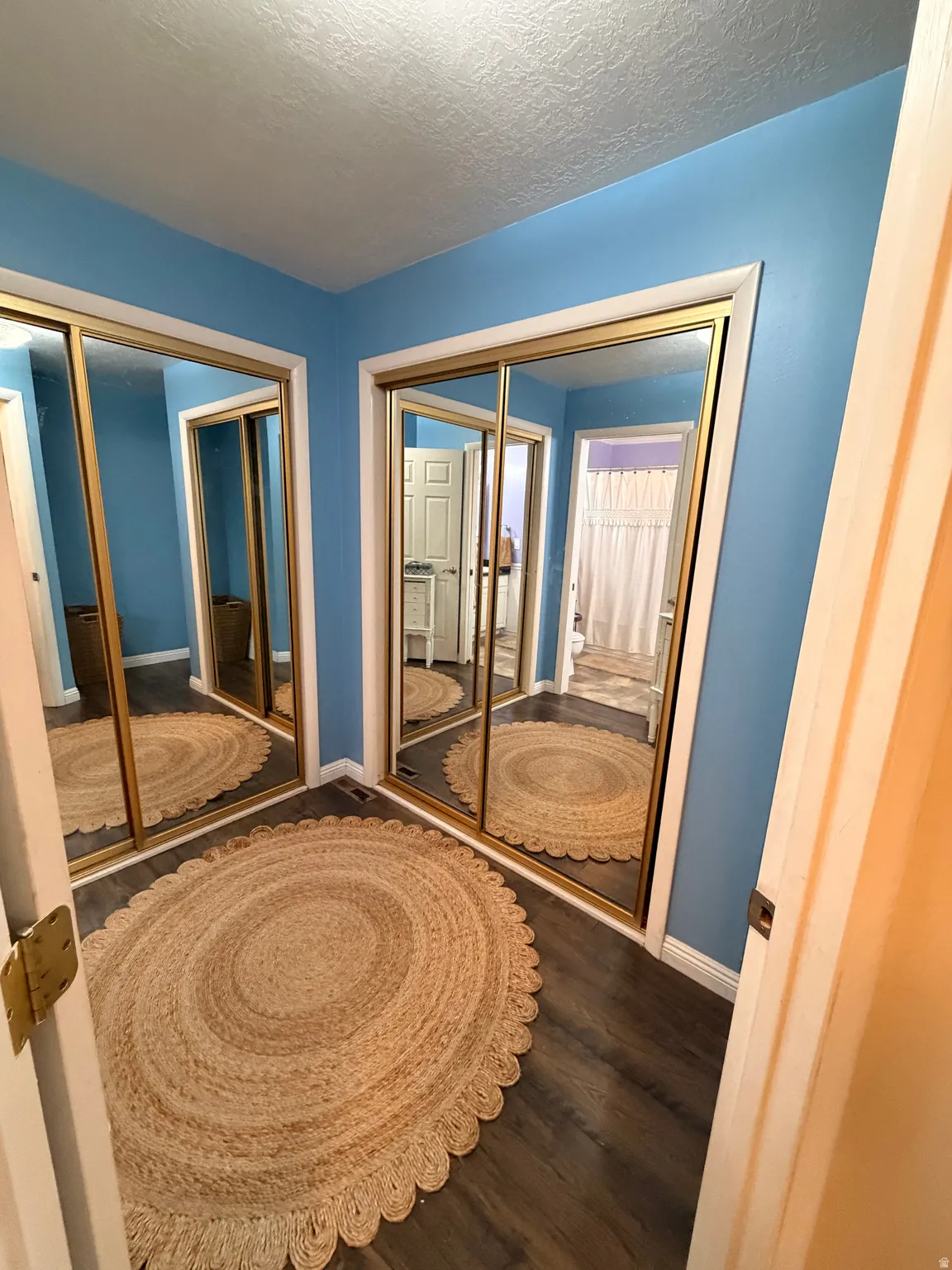 Unfurnished bedroom featuring dark wood-type flooring and a textured ceiling