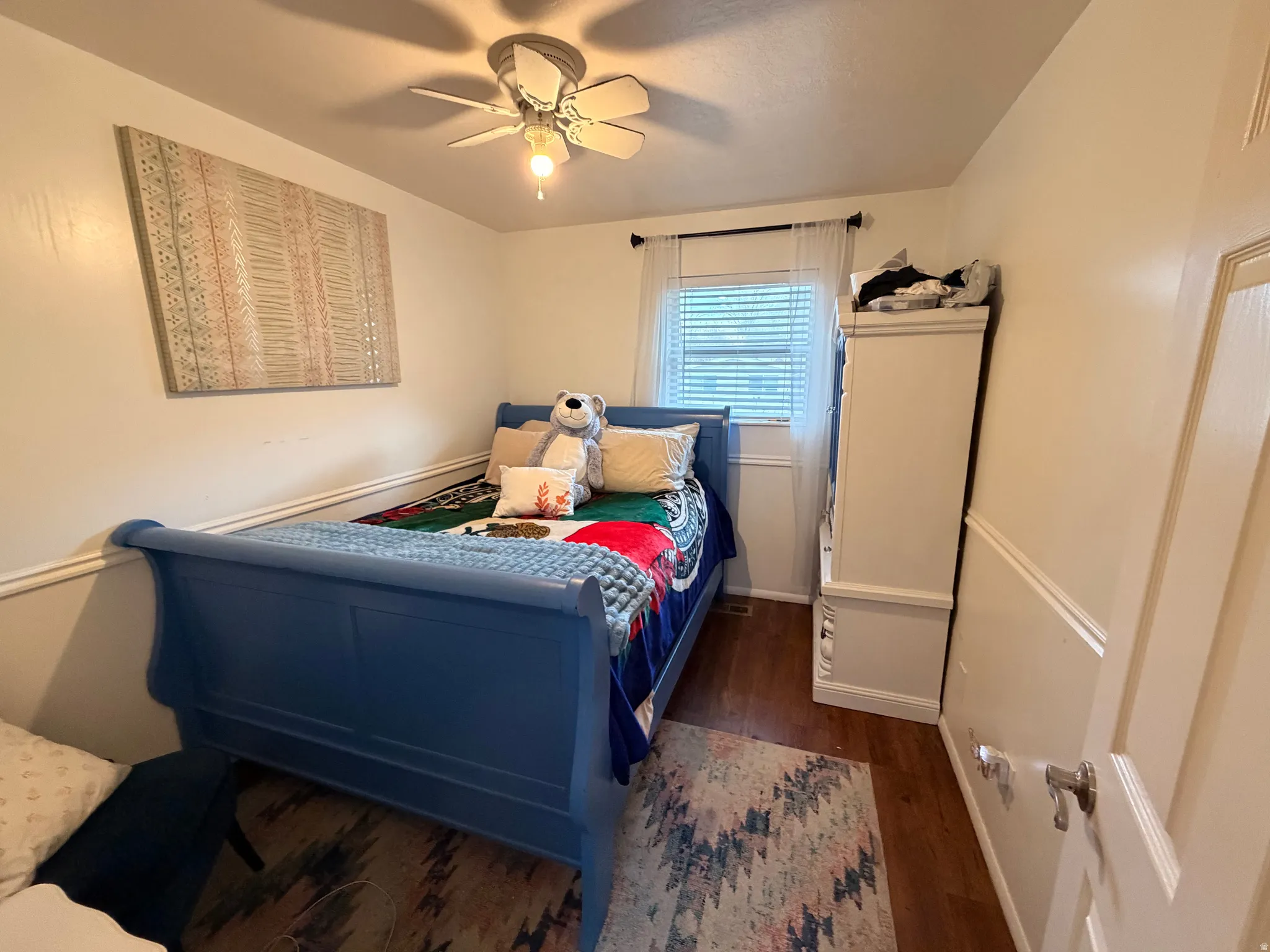Bedroom with dark wood finished floors and ceiling fan