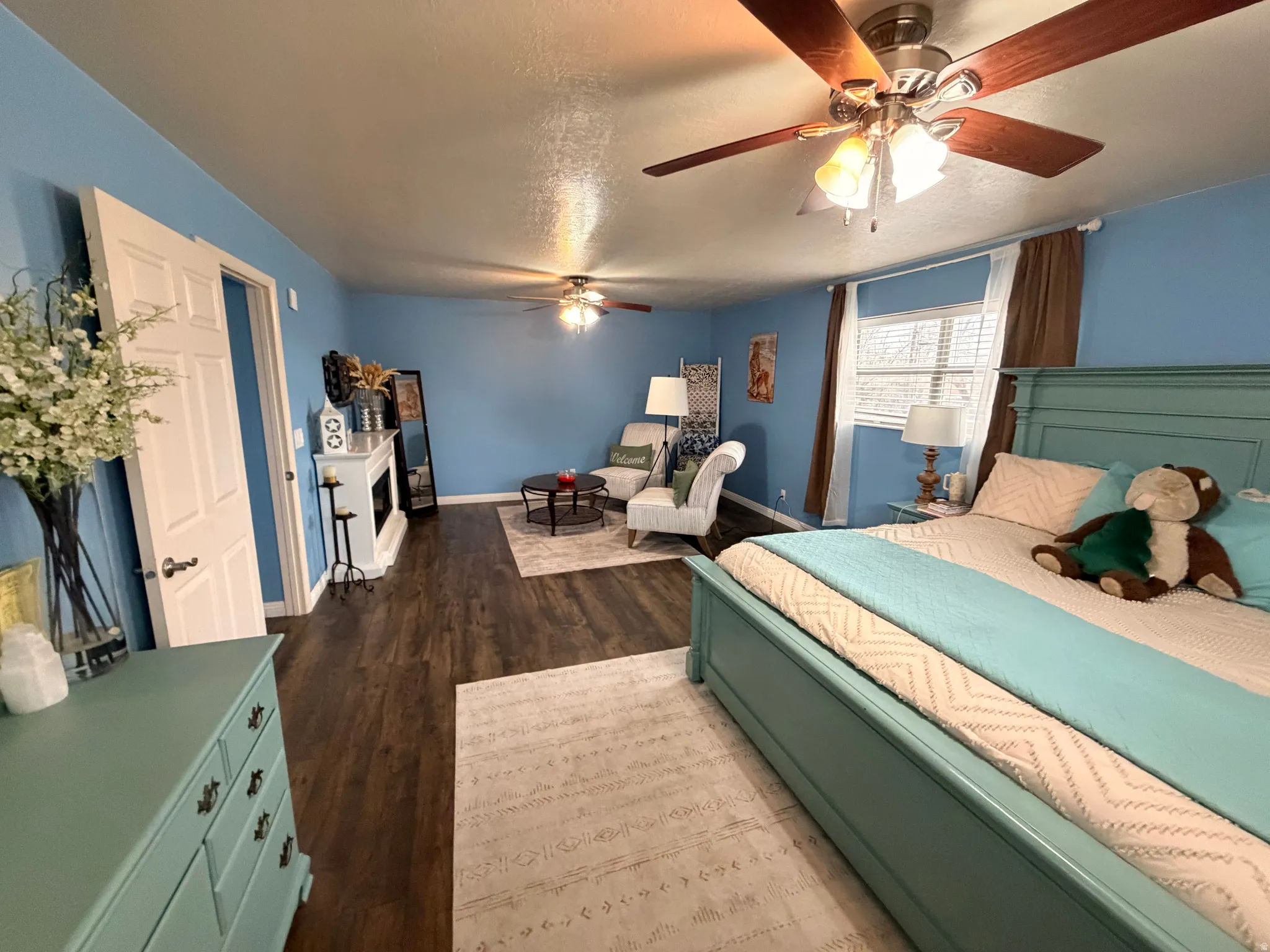 Bedroom with dark wood finished floors, a ceiling fan, and a textured ceiling