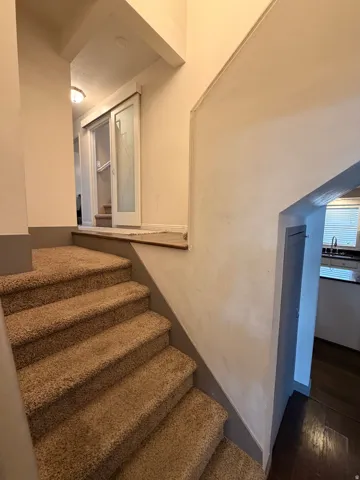 Stairway featuring wood finished floors and baseboards