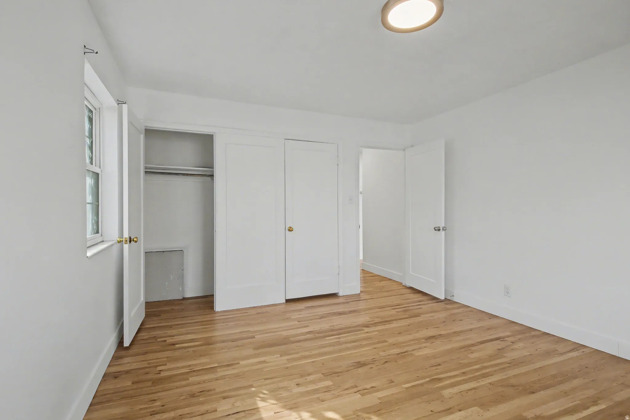 Unfurnished bedroom featuring light wood-style flooring and a closet