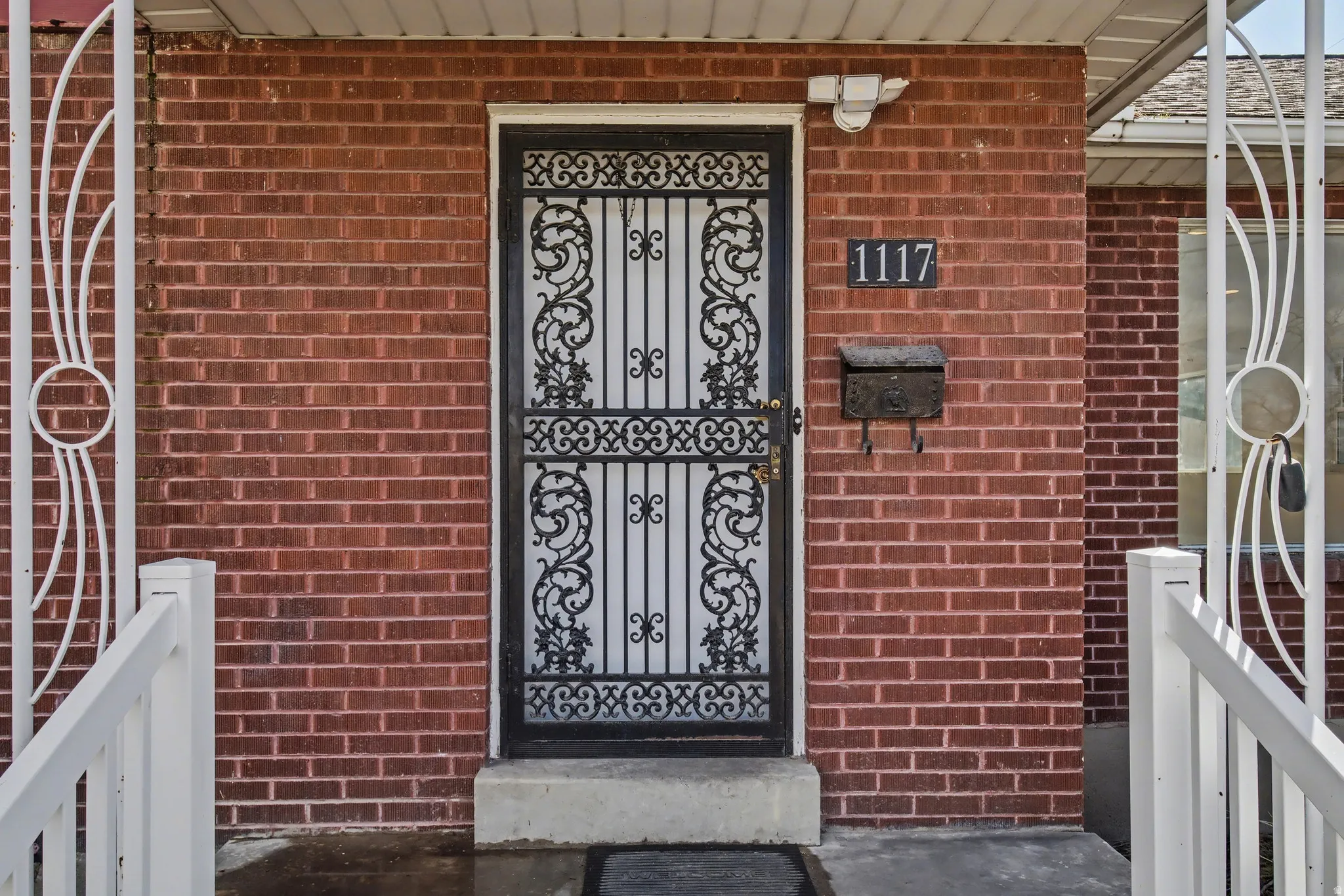 View of exterior entry featuring brick siding and a porch