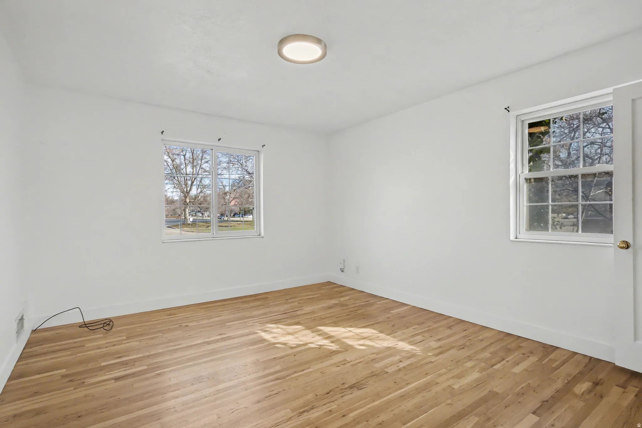 Spare room with light wood-style floors and baseboards