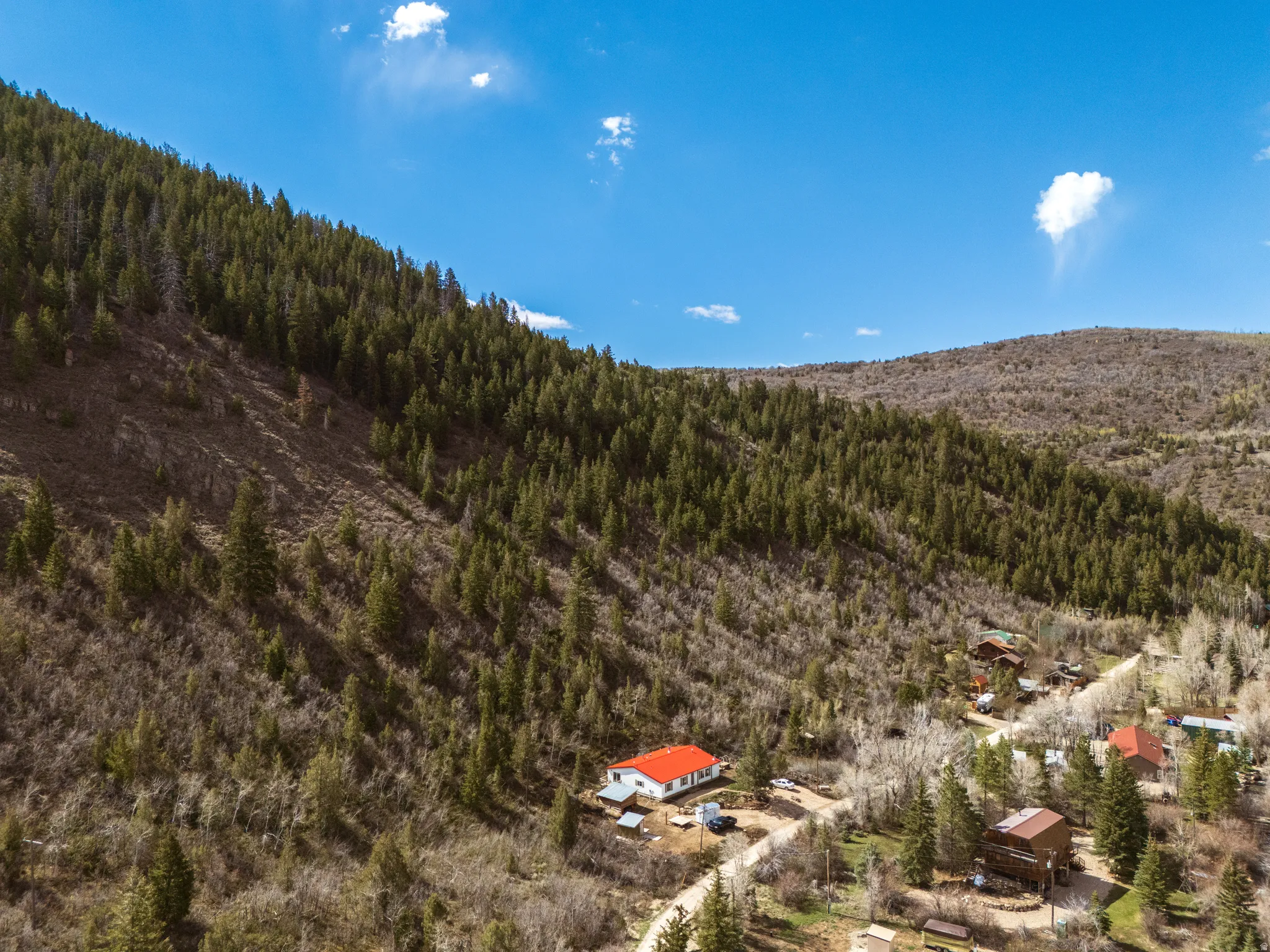 Aerial view of property with red metal roof
