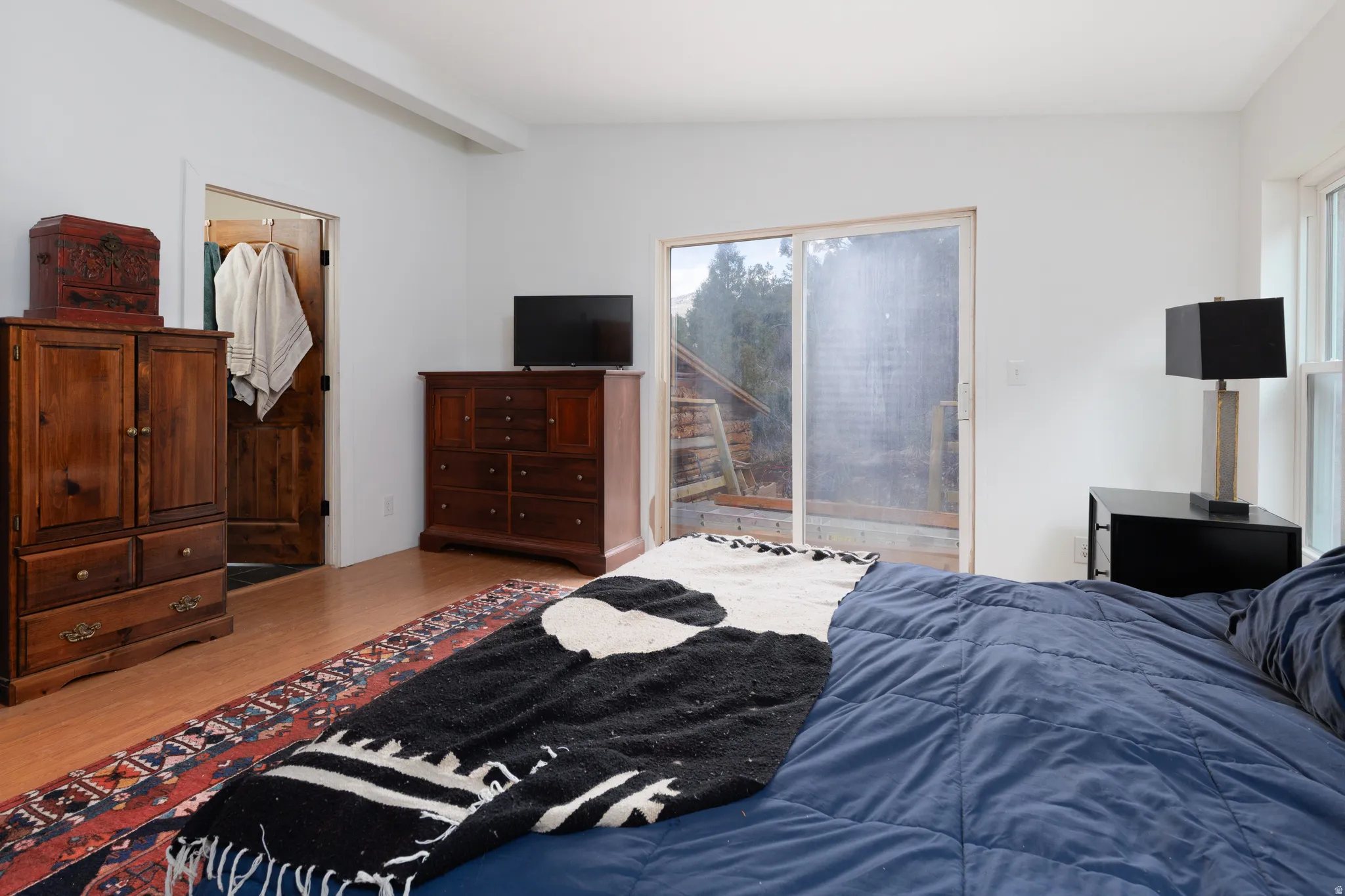 Bedroom with wood-style floors, access to exterior, and vaulted ceiling