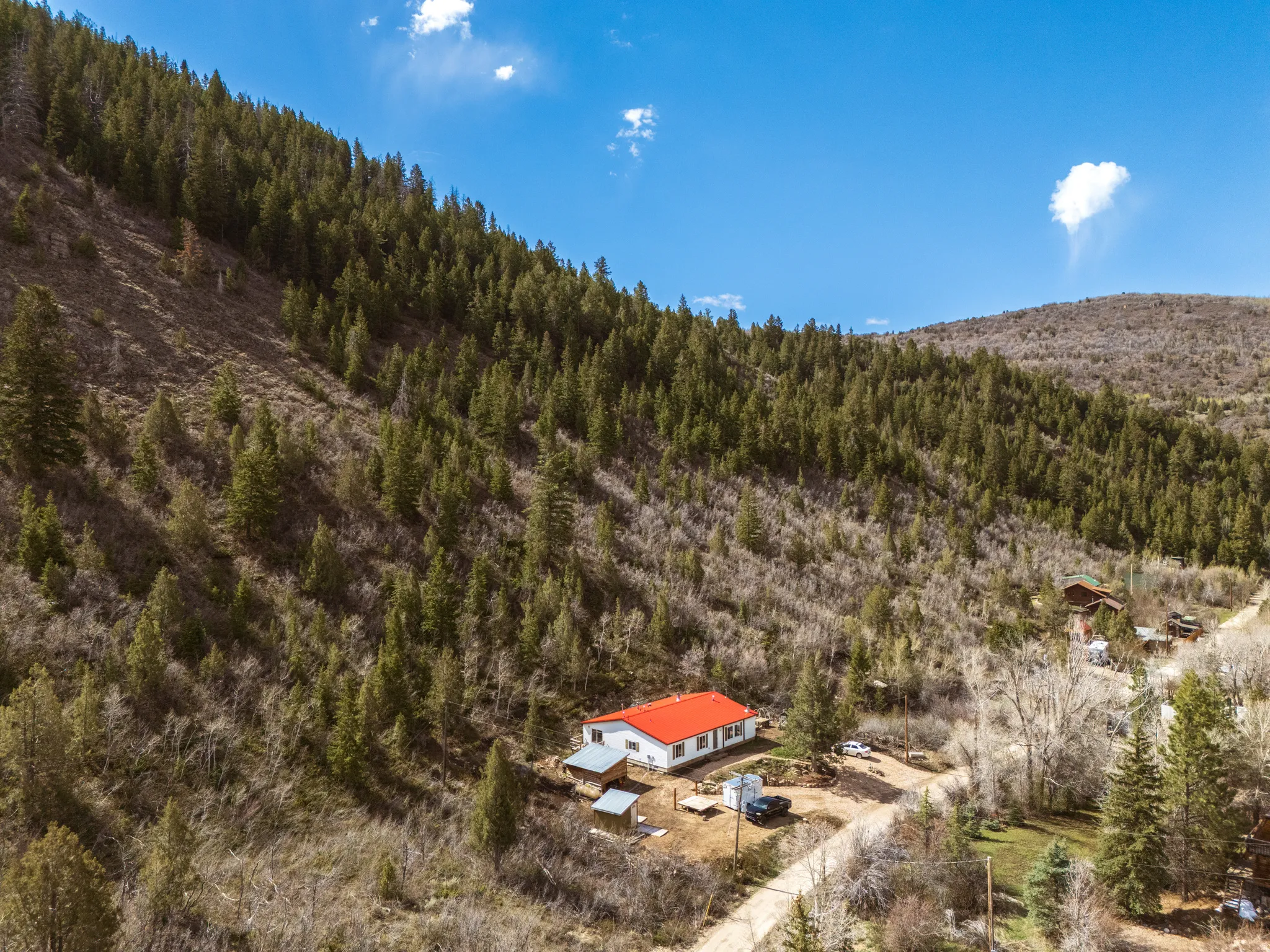 Aerial view of property with red metal roof