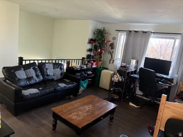 Living area with a desk and dark wood-type flooring