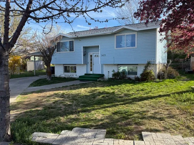 Bi-level home featuring brick siding and a front lawn