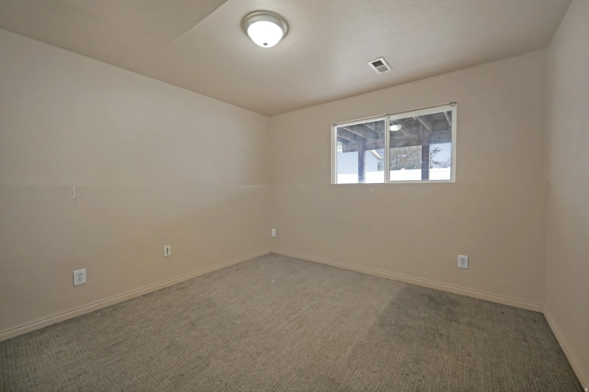 Carpeted empty room with baseboards