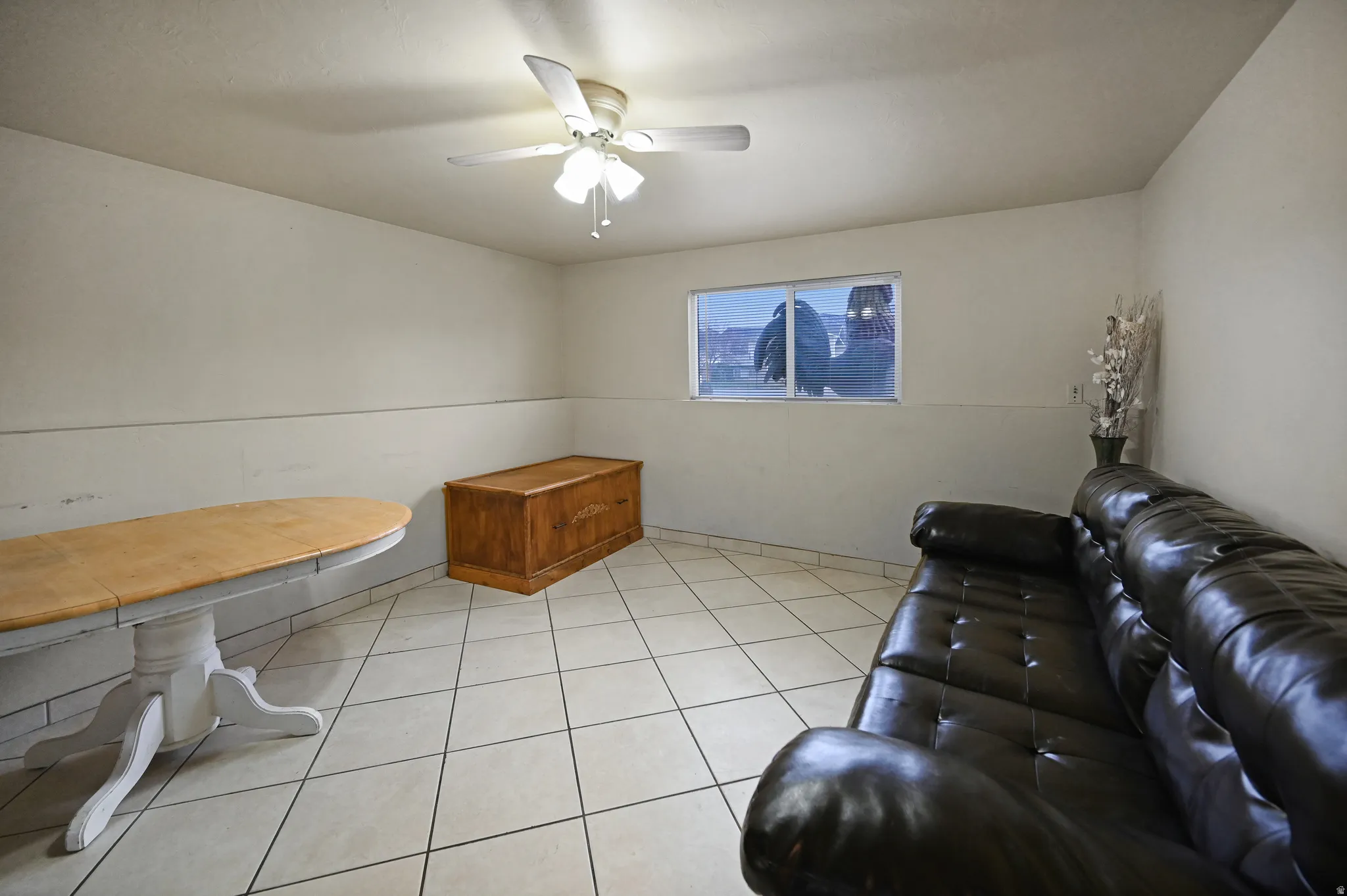 Living room with a ceiling fan and light tile patterned flooring