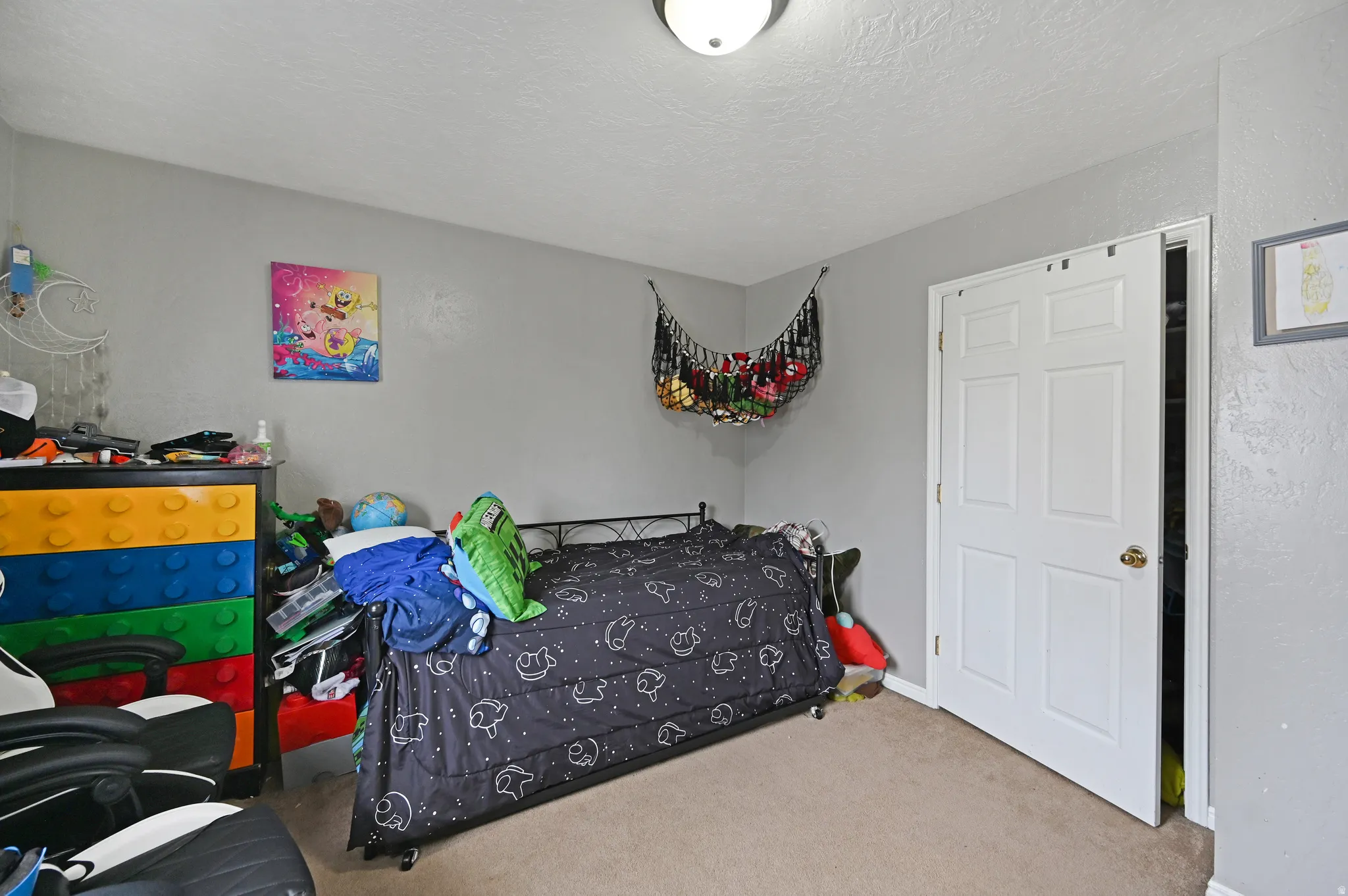 Carpeted bedroom featuring a textured ceiling and a textured wall