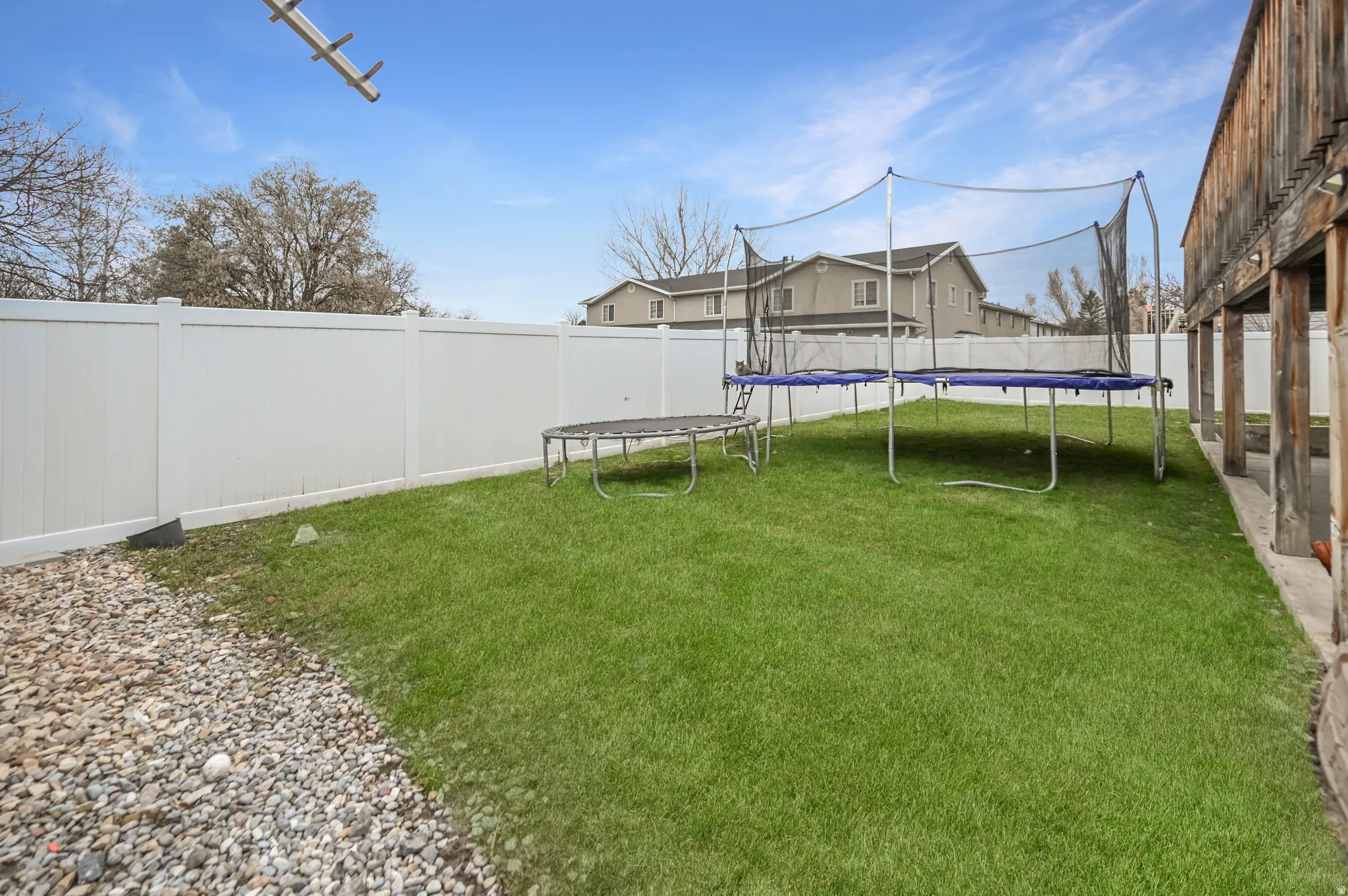 Fenced backyard with a trampoline