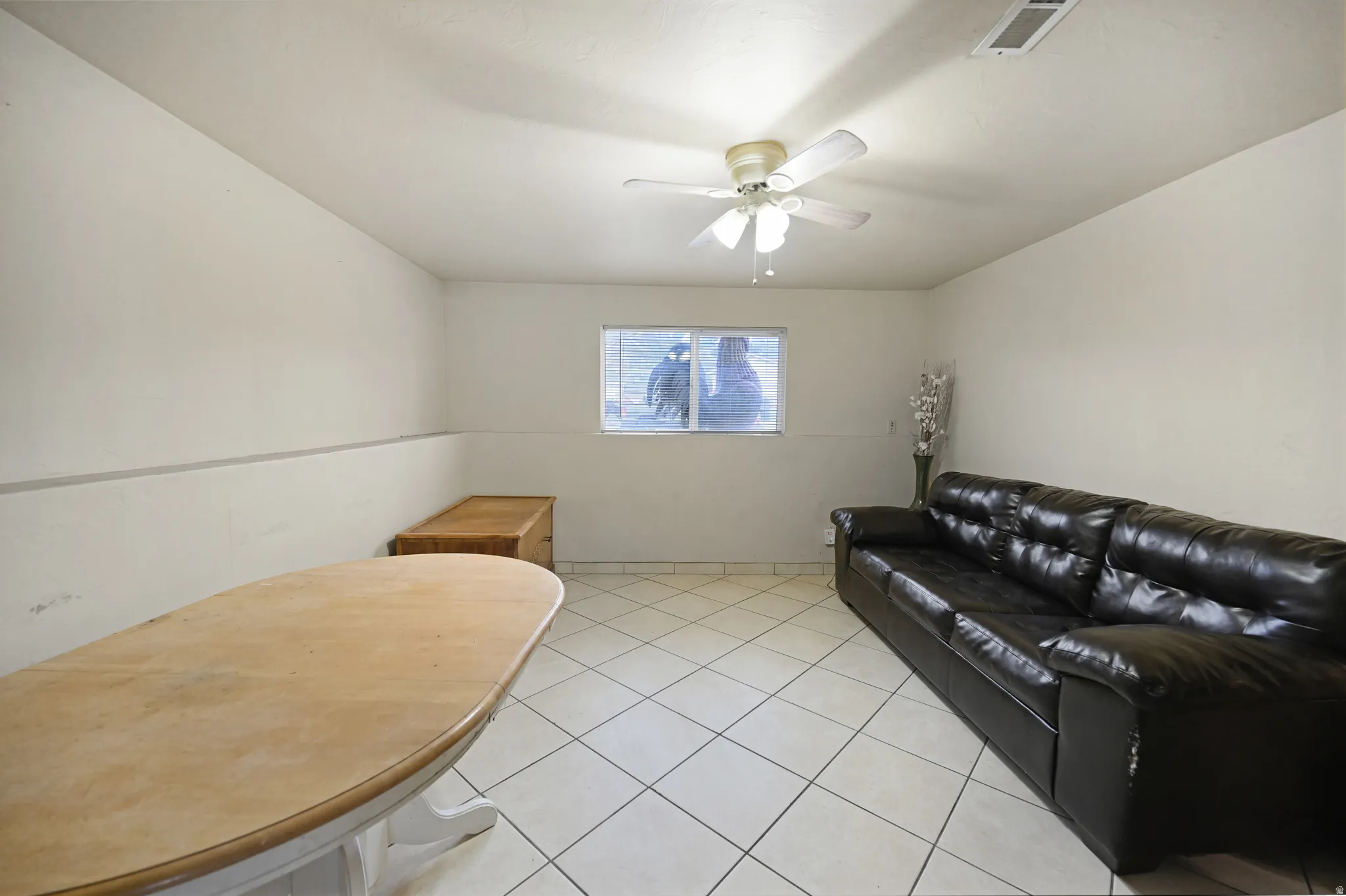 Living room with light tile patterned floors and a ceiling fan
