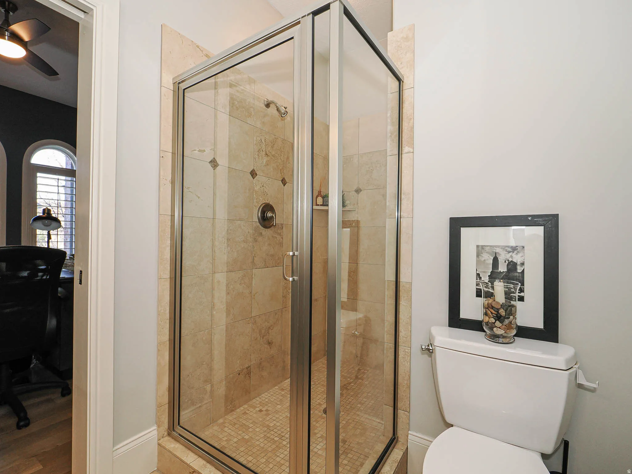 Full bath featuring a stall shower and a ceiling fan