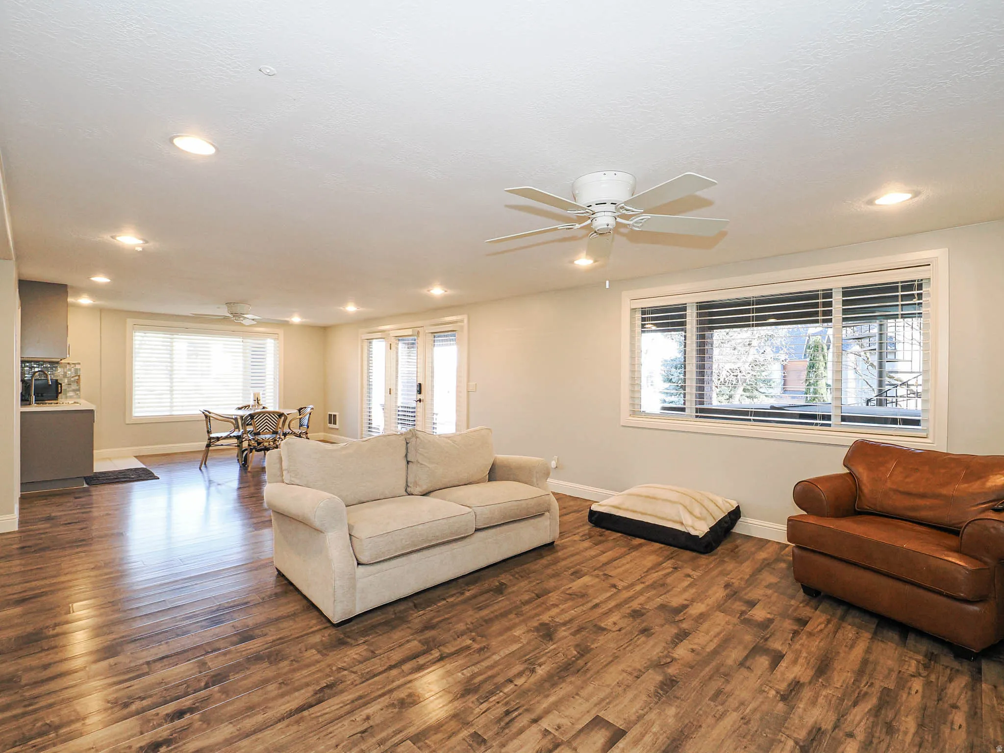 Living room with a ceiling fan, dark wood-type flooring, healthy amount of natural light, and recessed lighting