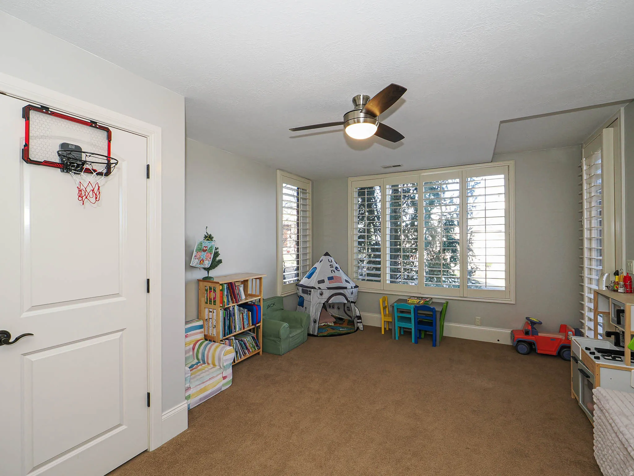 Playroom featuring ceiling fan and carpet flooring