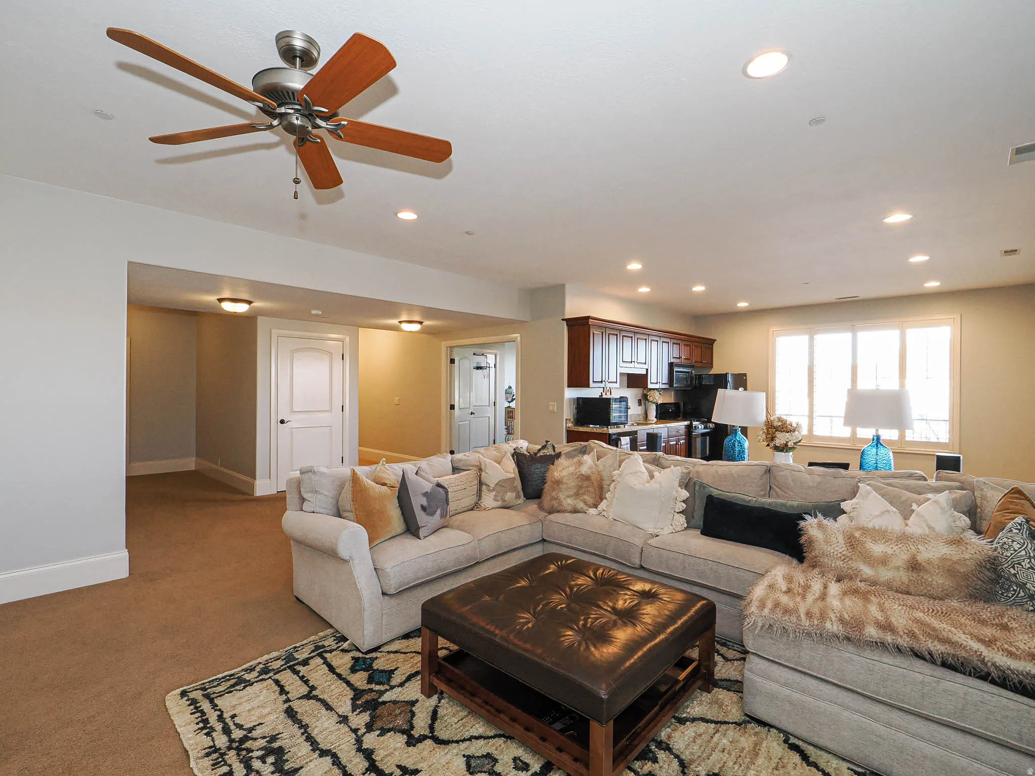 Living area with carpet floors, ceiling fan, and recessed lighting