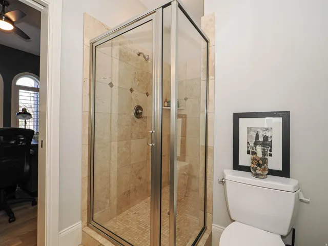 Full bath featuring a stall shower and a ceiling fan