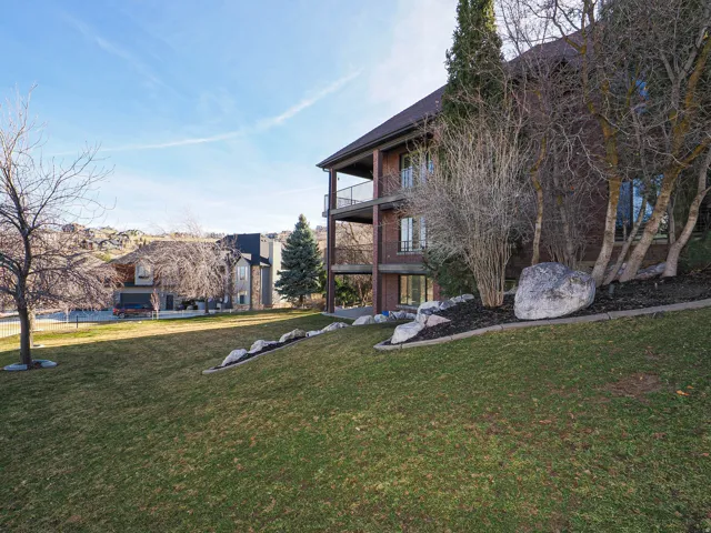 View of grassy yard with a balcony