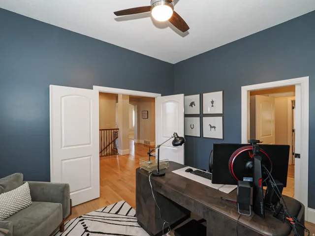 Office area with light wood finished floors and a ceiling fan