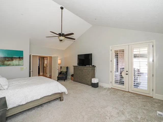 Carpeted bedroom with french doors, access to exterior, and a ceiling fan