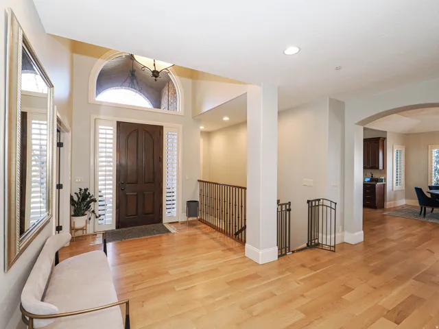 Entrance foyer featuring light wood finished floors, arched walkways, recessed lighting, and a high ceiling