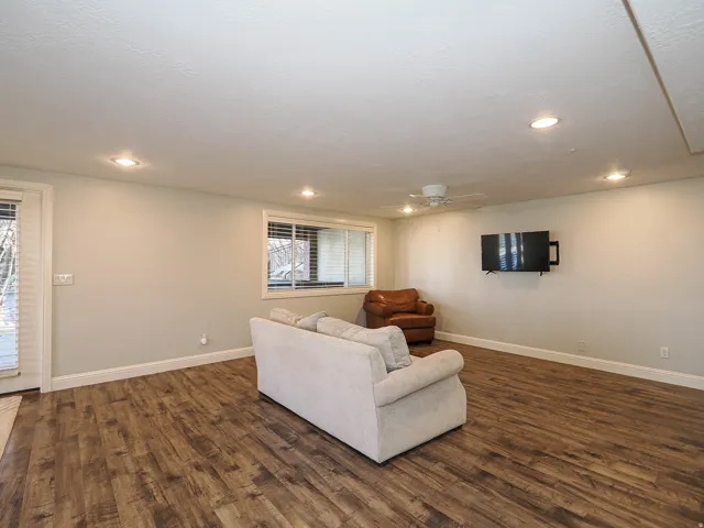 Living room with dark wood finished floors, a ceiling fan, and recessed lighting