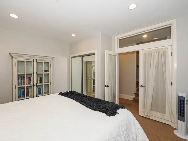 Bedroom with a closet, dark carpet, and recessed lighting
