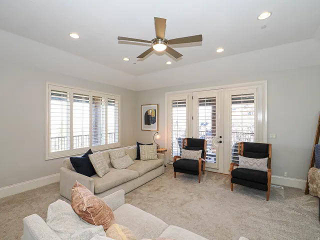Living room with french doors, light colored carpet, a ceiling fan, plenty of natural light, and recessed lighting