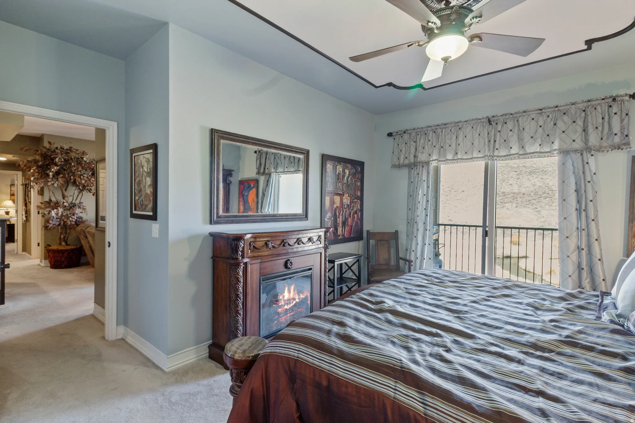 Carpeted bedroom featuring access to exterior and a ceiling fan