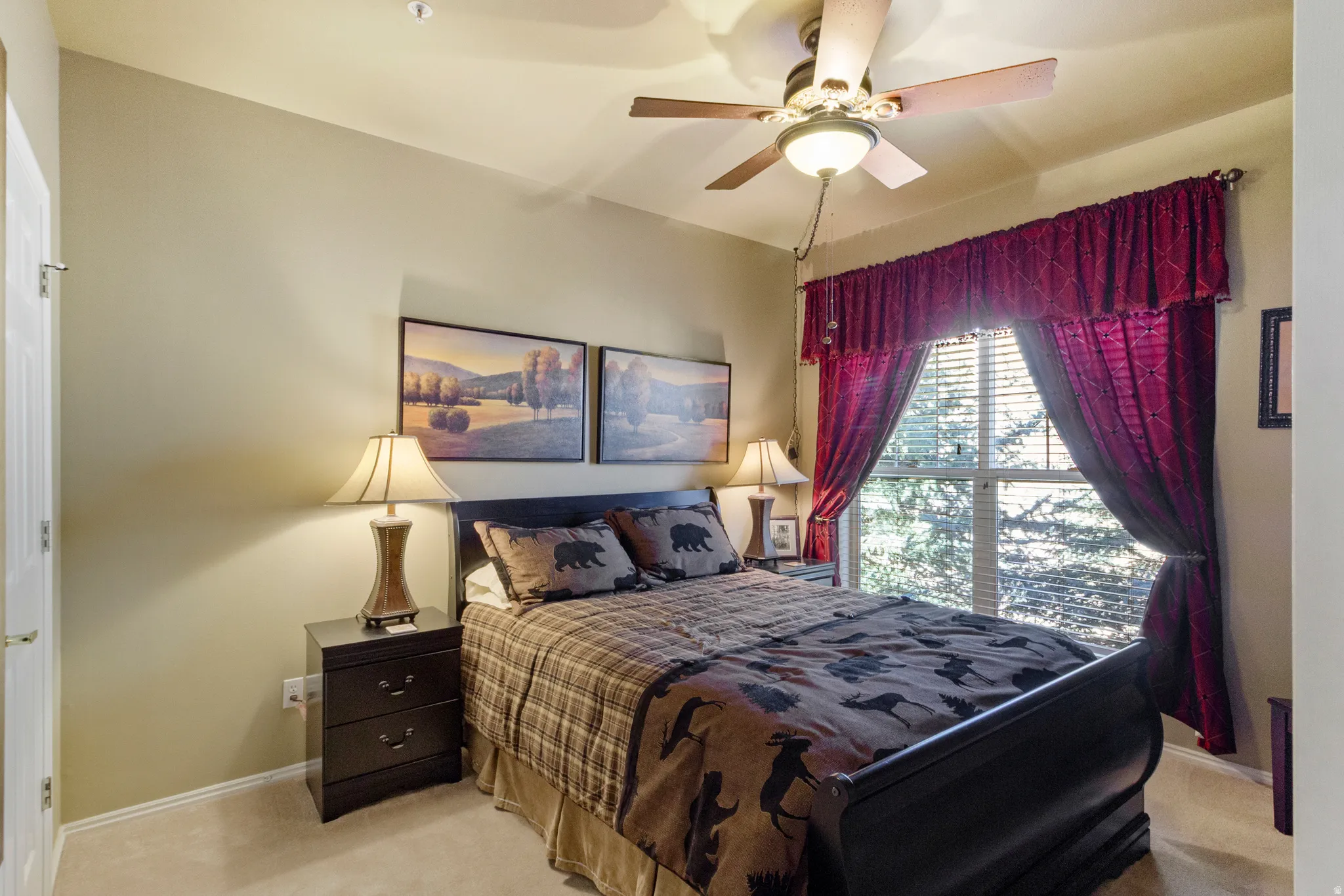 Carpeted bedroom with baseboards and a ceiling fan