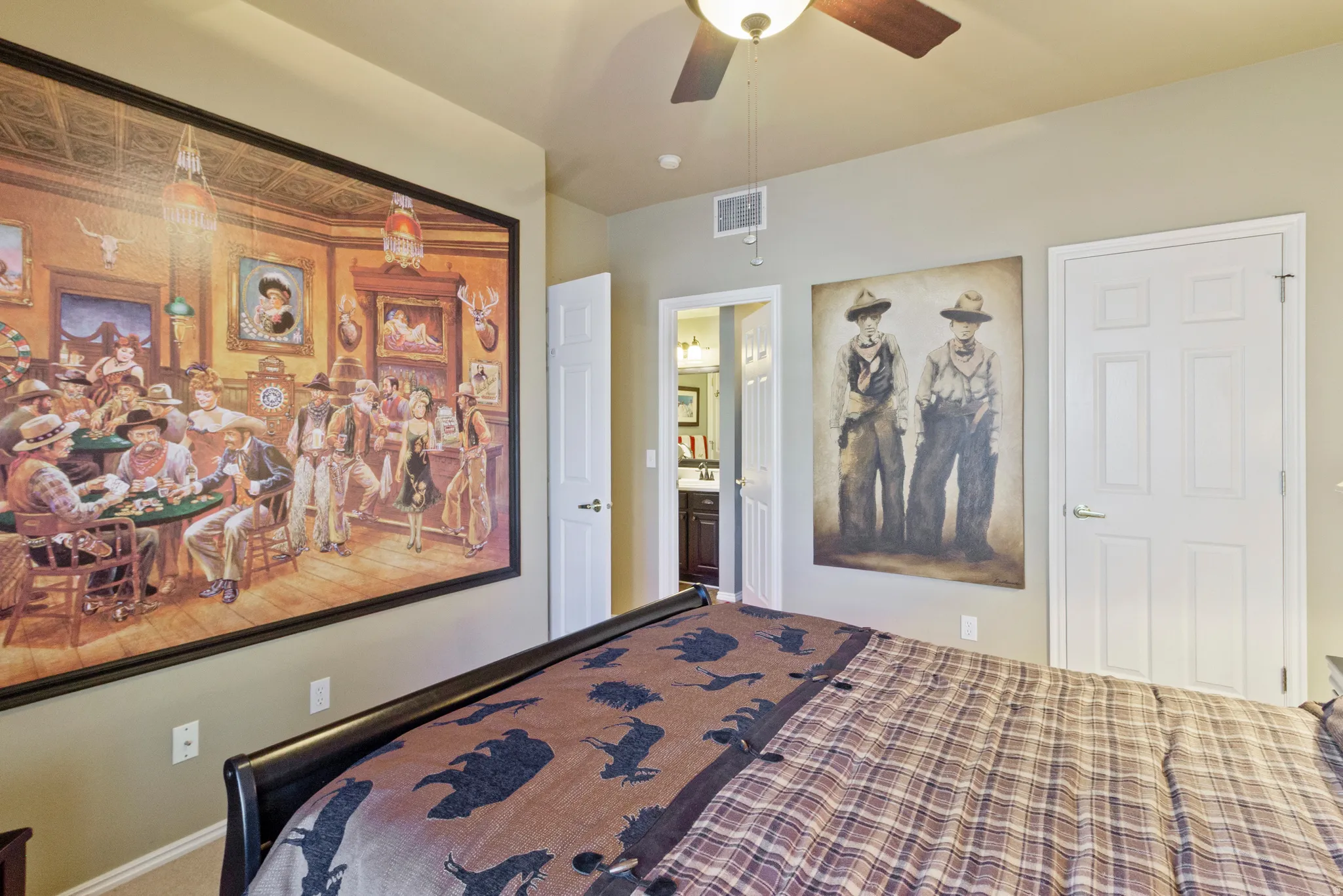 Carpeted bedroom with connected bathroom and a ceiling fan