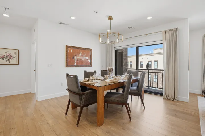 Dining space with suspended lighting and light wood-style floors