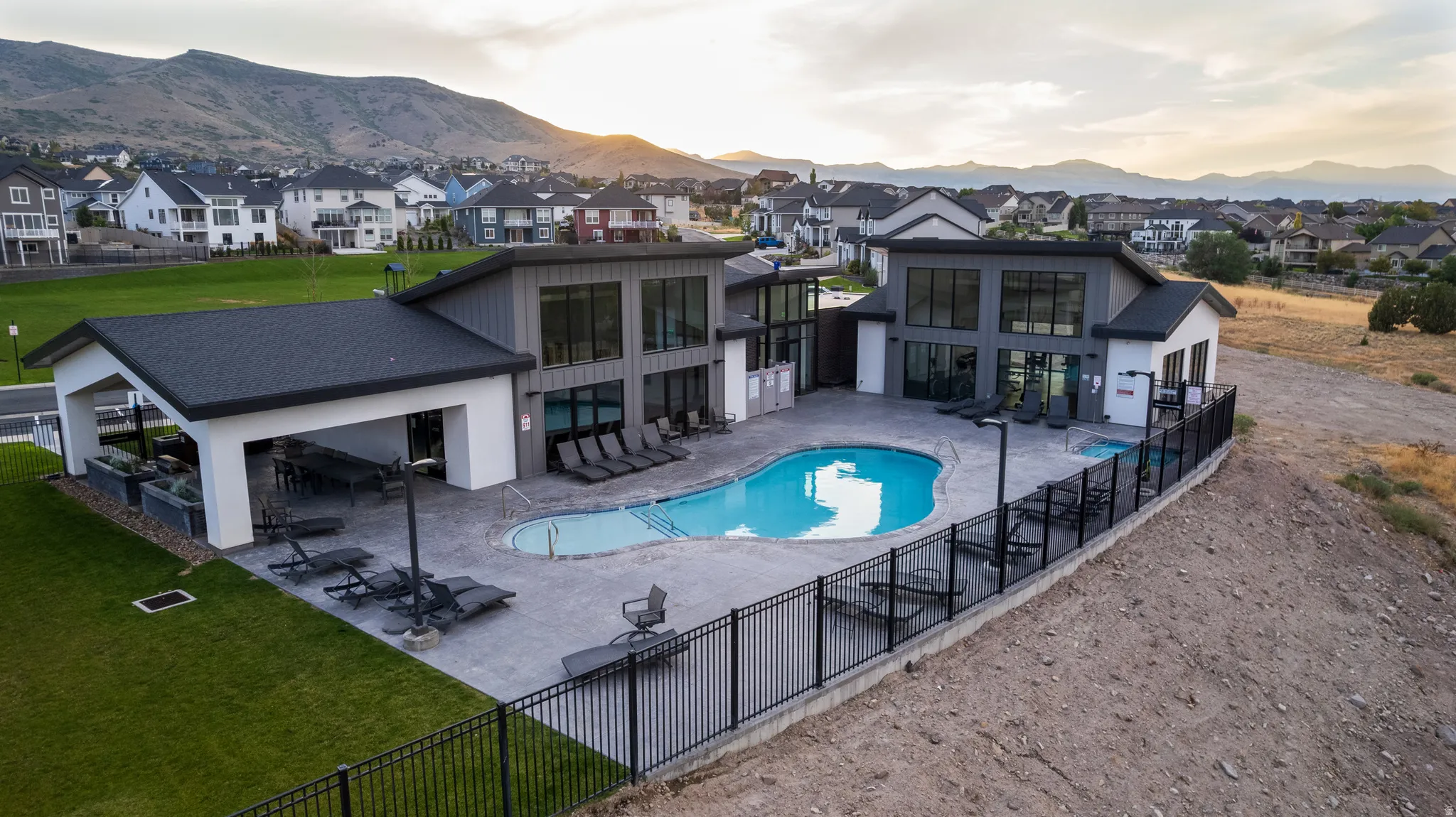 Back of property with a patio area, a community pool, stucco siding, a mountain view, and a residential view