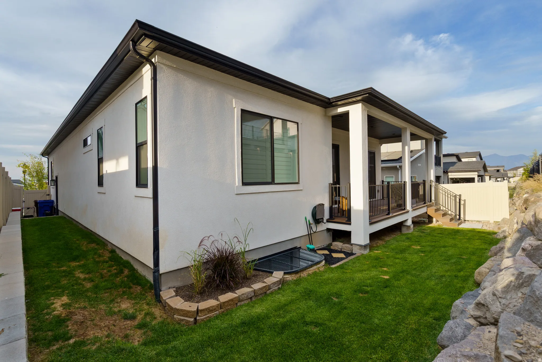 View of side of home with a deck and stucco siding